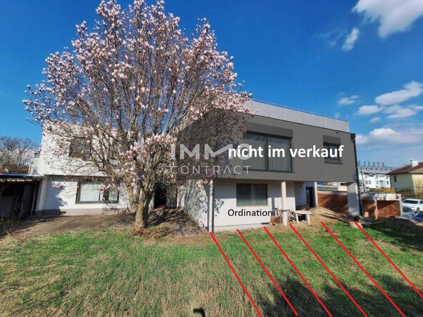 Ansicht der modernen Gebäudefassade mit blühendem Baum und markierten Grundstücksgrenzen.