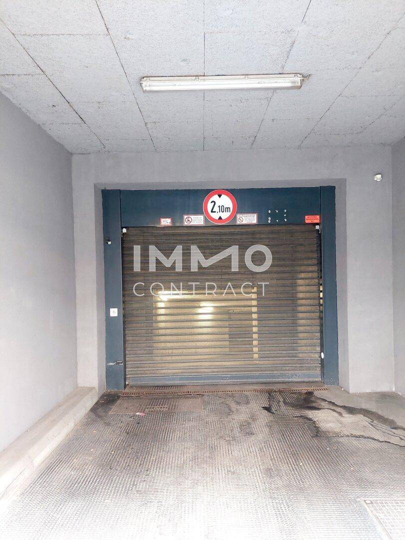 Rolltor der Tiefgarage mit Höhenbegrenzung von 2,10 Metern und Deckenbeleuchtung.