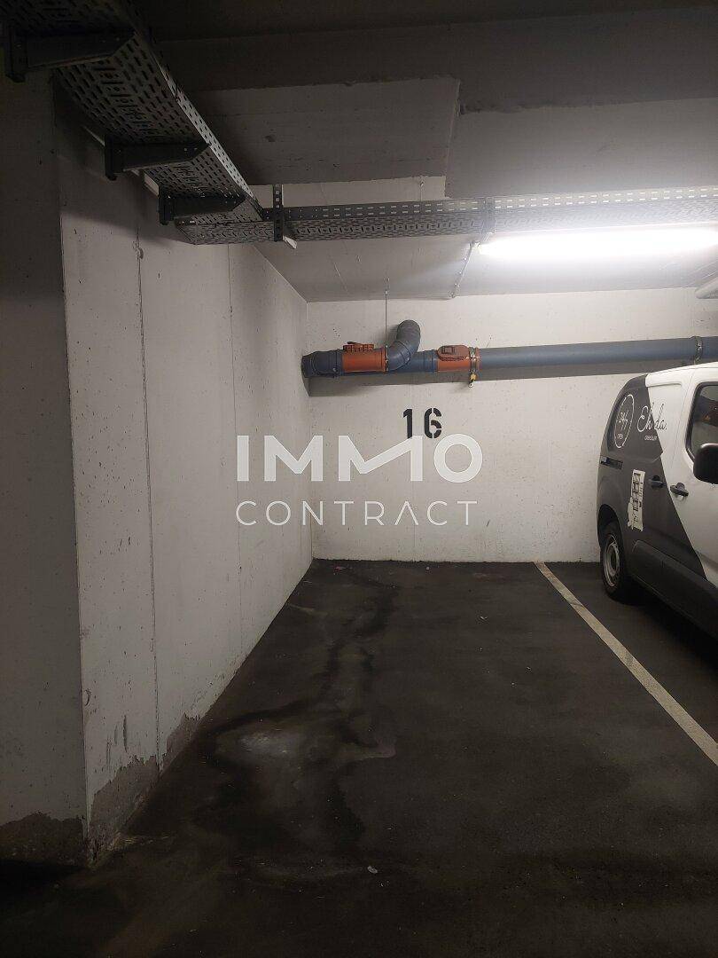 Parkplatz Nummer 16 in einer Tiefgarage mit sichtbaren Kabeltrassen und Rohren.