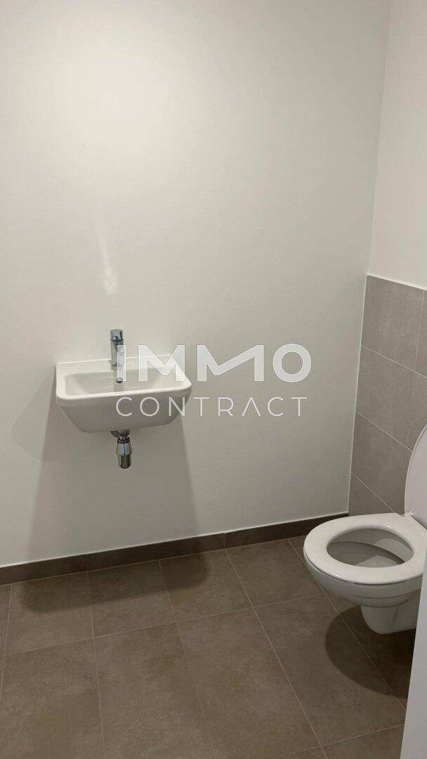 Kleines Gäste-WC mit modernem Waschbecken und Toilette, in neutralen Farbtönen gehalten.