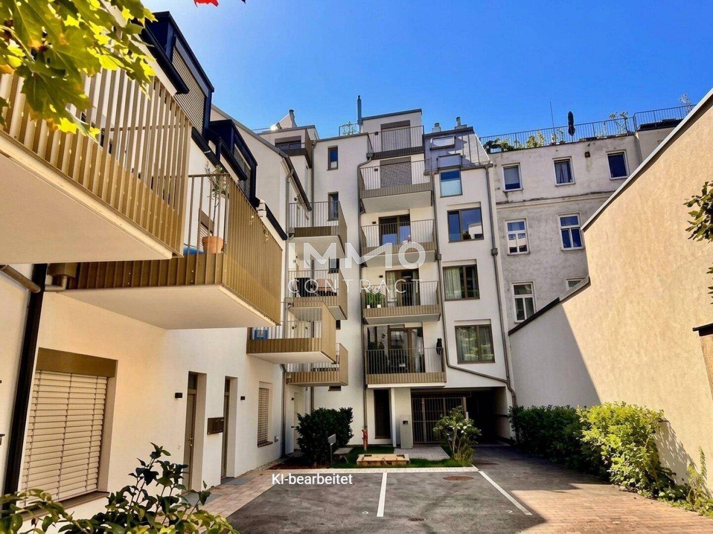 Moderne Wohnanlage mit mehreren Balkonen und einem Innenhof mit Parkplätzen.