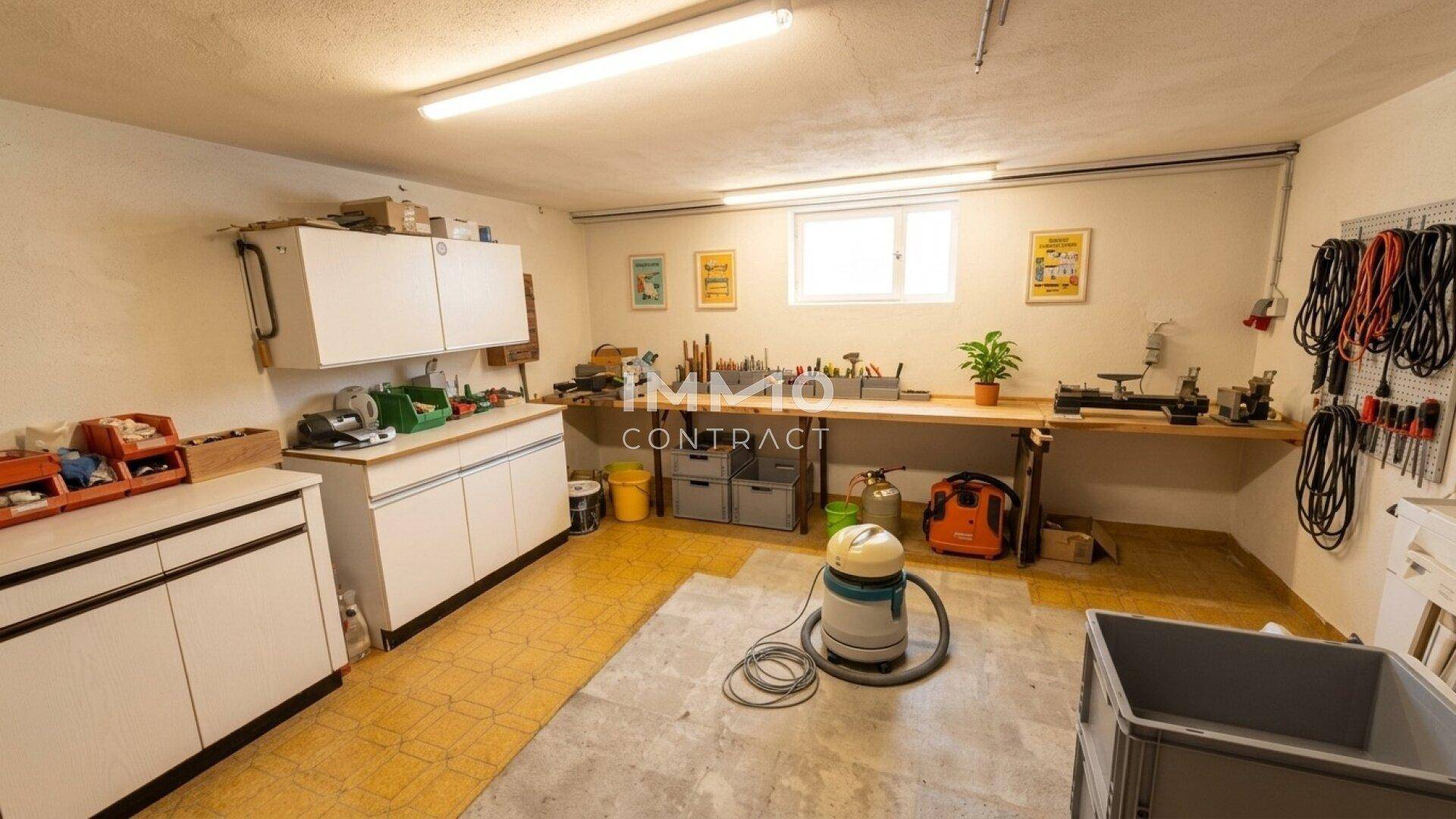 Geräumiger Hobbyraum oder Werkstatt im Keller mit Werkbank und Stauraum.