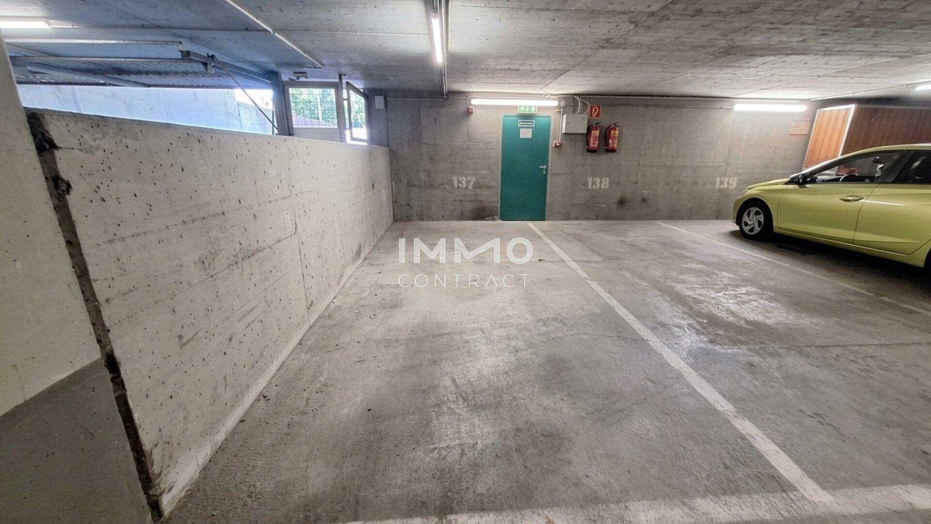 Geräumige Tiefgarage mit Betonwänden und markierten Parkplätzen für Fahrzeuge.