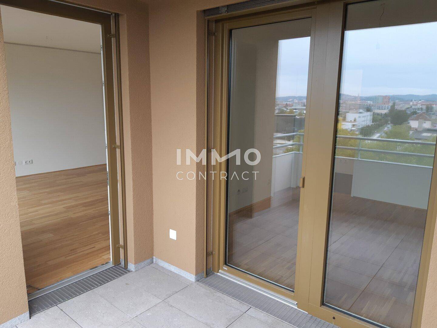 Geräumiger Balkon mit Fliesenboden und weitem Blick über die Stadt.
