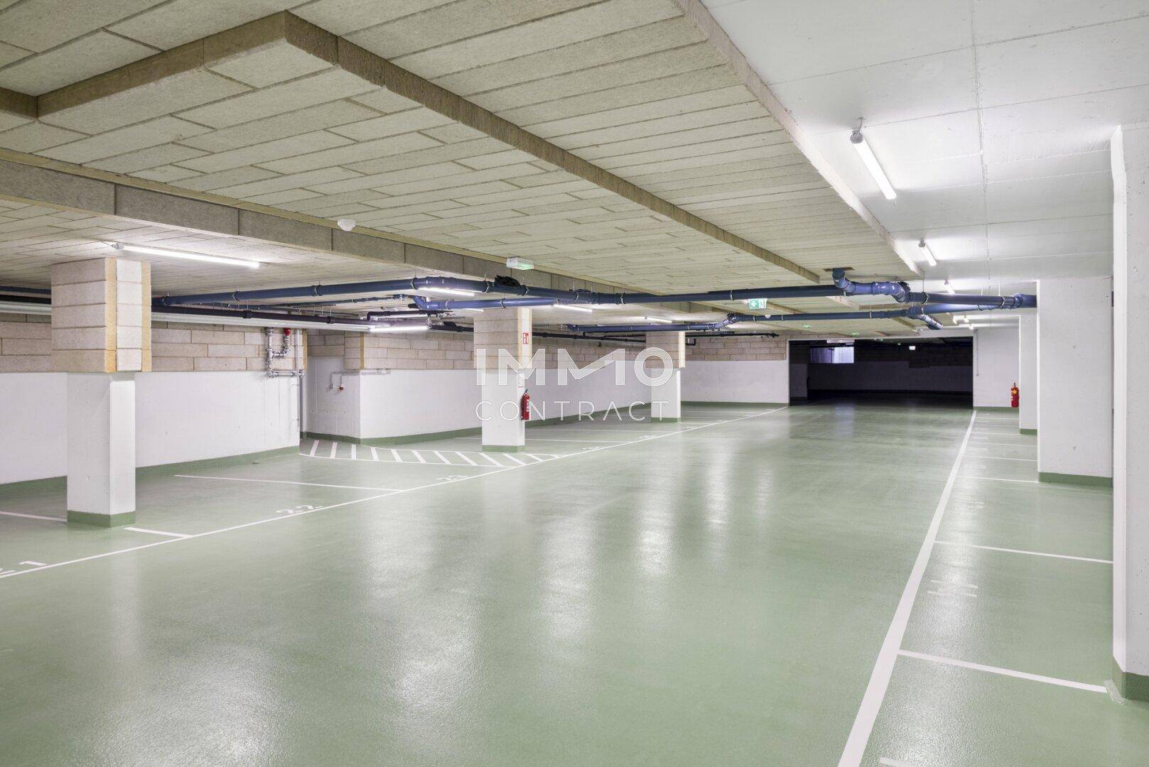 Geräumige Tiefgarage mit markierten Stellplätzen und guter Beleuchtung.