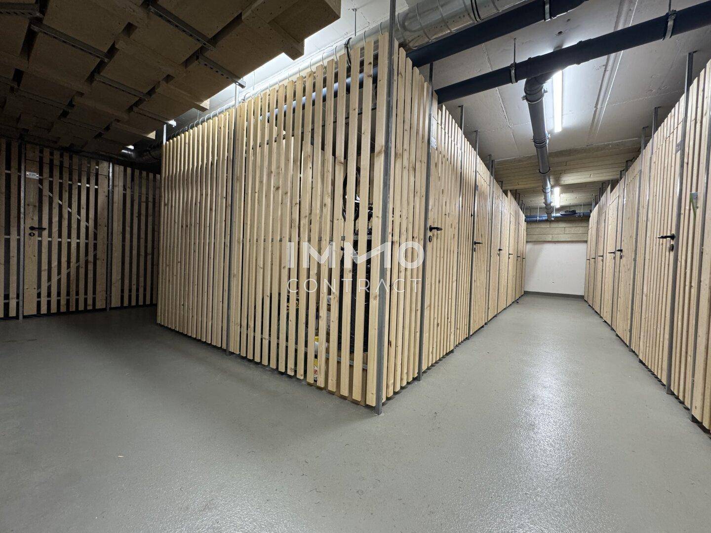 Abgetrennte Kellerabteile aus Holzlatten bieten zusätzlichen Stauraum für Bewohner.