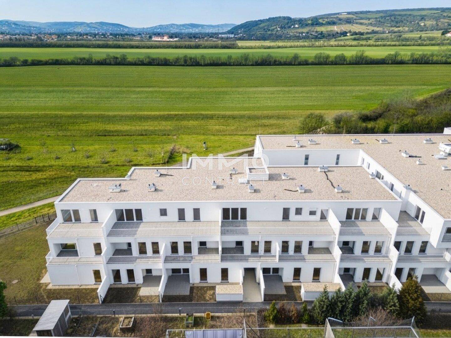 Luftaufnahme der modernen Wohnanlage eingebettet in eine grüne Landschaft.