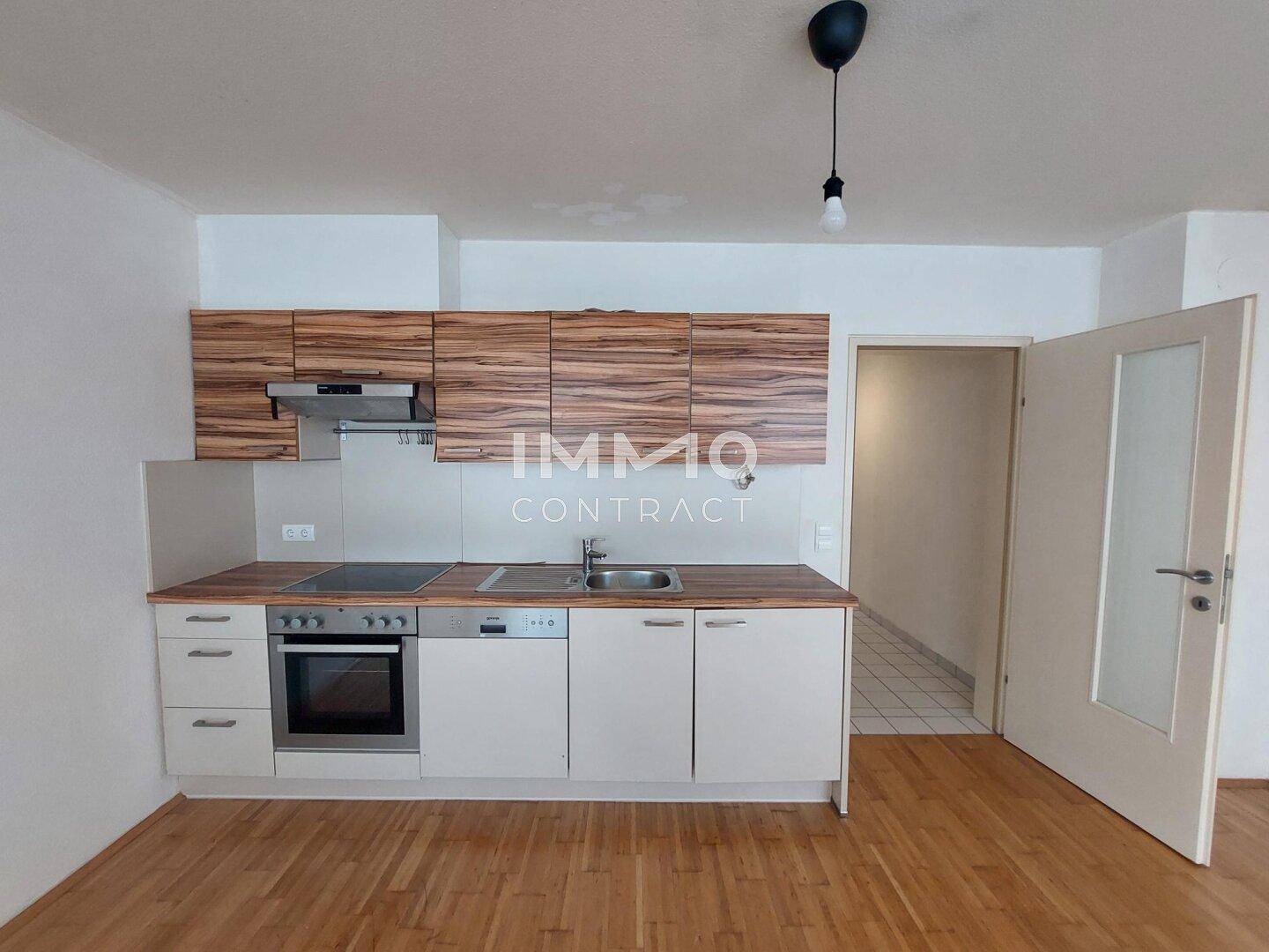 Moderne Küchenzeile mit Holzfronten, integrierten Geräten und Spüle.