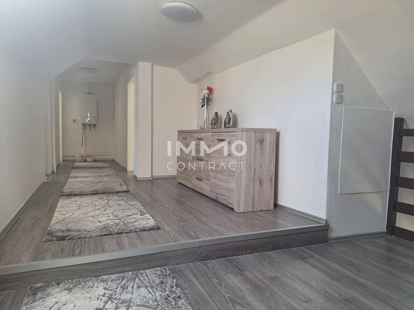 Heller Dachgeschossflur mit Laminatboden und Kommode.