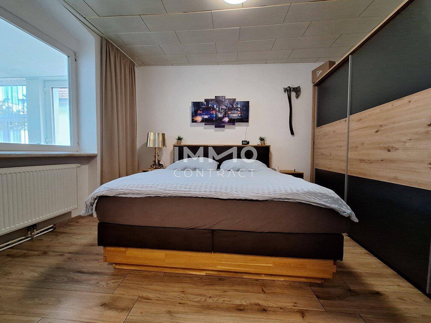 Schlafzimmer mit Holzboden, großem Bett und Einbauschränken.