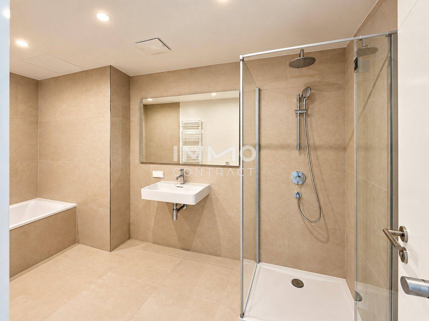 Modernes Badezimmer mit beigefarbenen Fliesen, Dusche und wandhängendem Waschbecken.