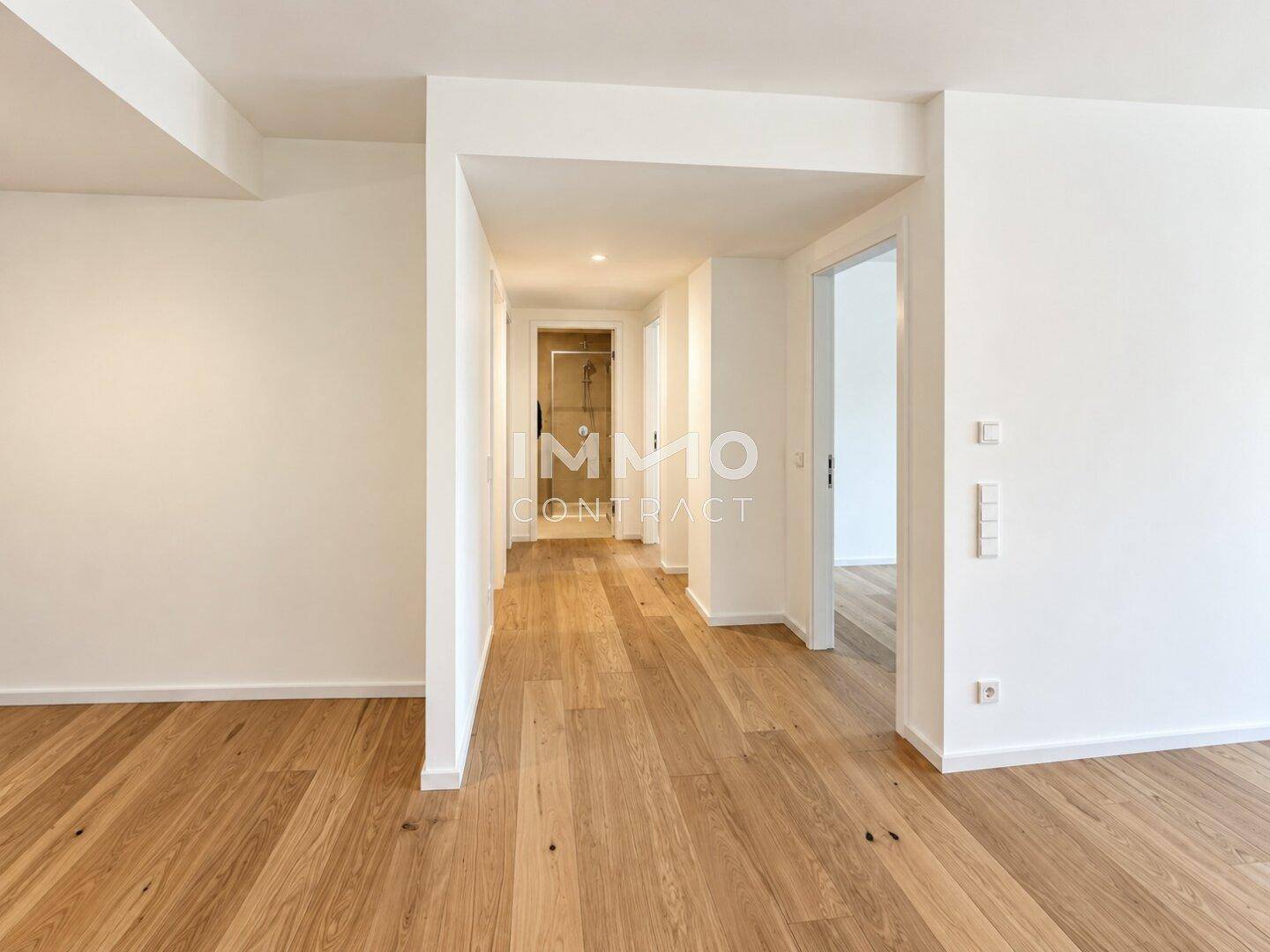 Heller Flur mit Eichenparkettboden, der zu verschiedenen Zimmern der Wohnung führt.
