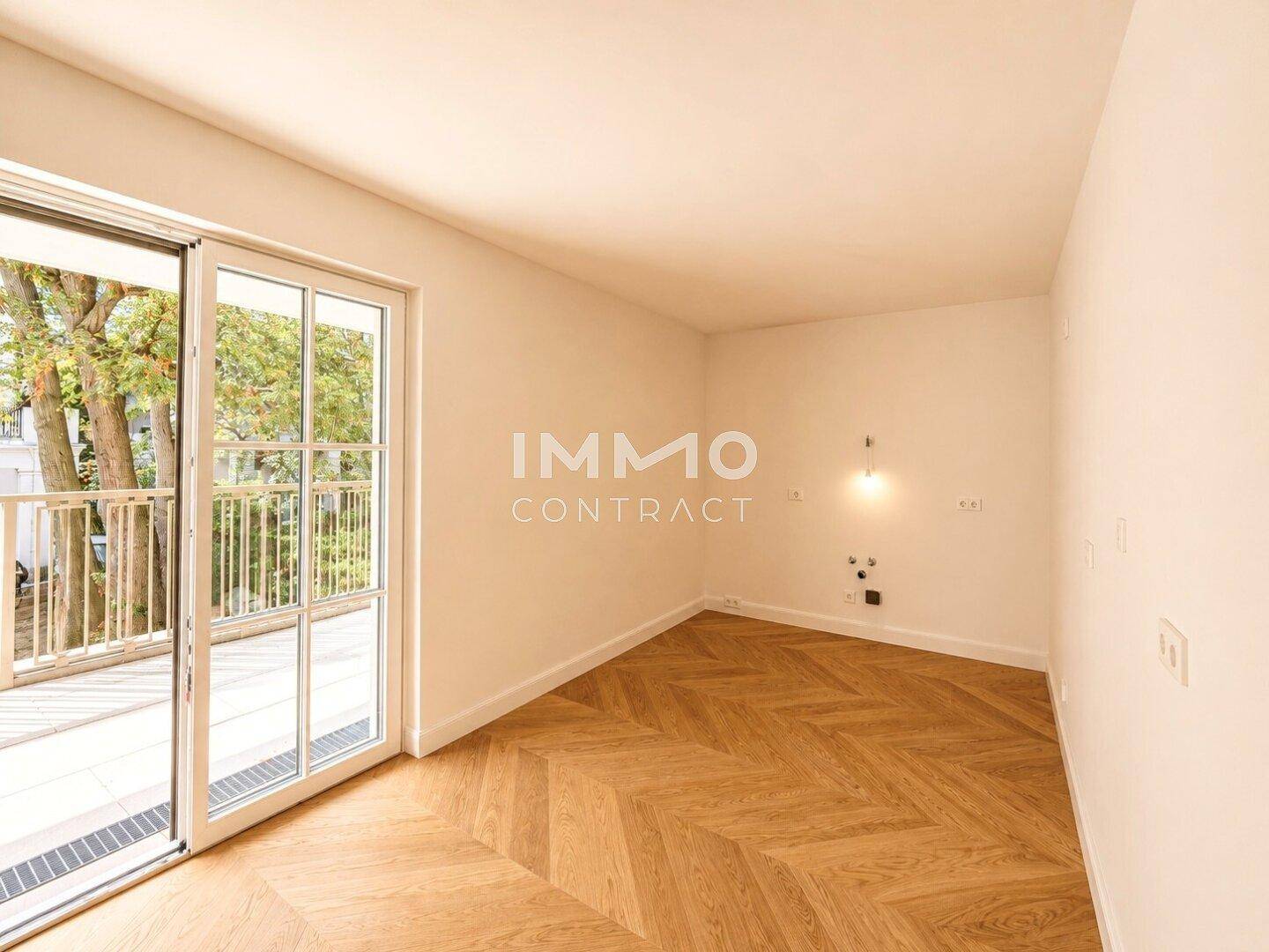 Helles Zimmer mit Fischgrätparkett und direktem Zugang zu einem Außenbereich, ideal als Schlafzimmer.