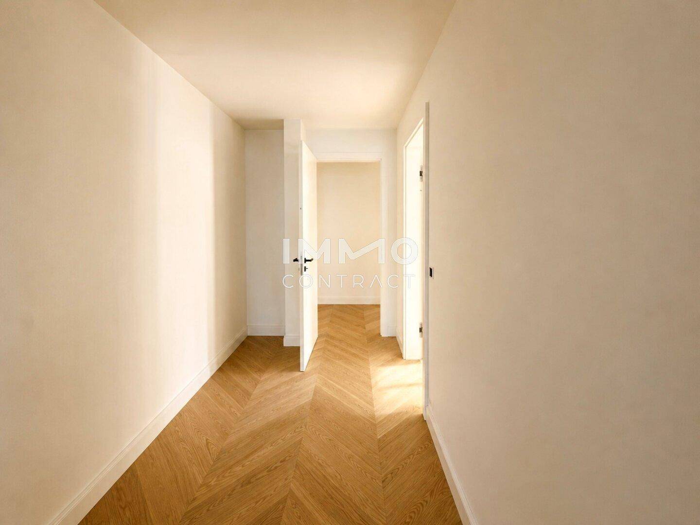 Heller Flur mit Fischgrätparkett, der zu verschiedenen Räumen der Wohnung führt.