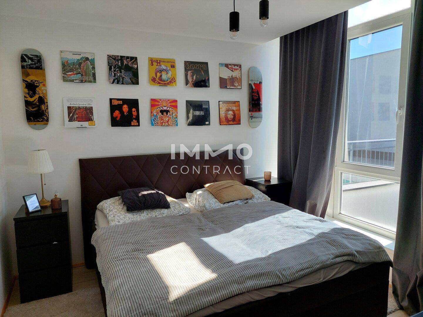Gemütliches Schlafzimmer mit Doppelbett, Nachttischen und dekorativen Skateboards an der Wand.