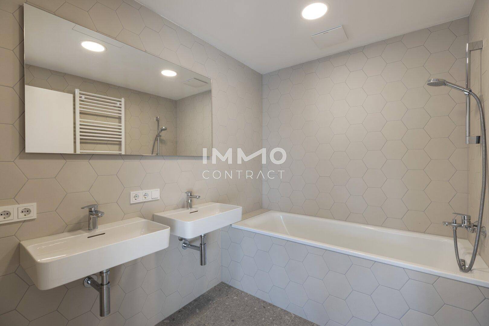 Modernes Badezimmer mit Doppelwaschbecken, Badewanne und sechseckigen Fliesen, sehr stilvoll.