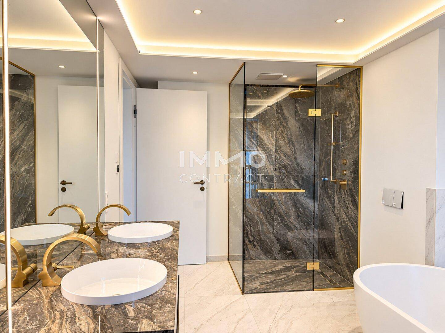 Elegantes Badezimmer mit Marmoroberflächen, freistehender Badewanne und großer begehbarer Dusche.