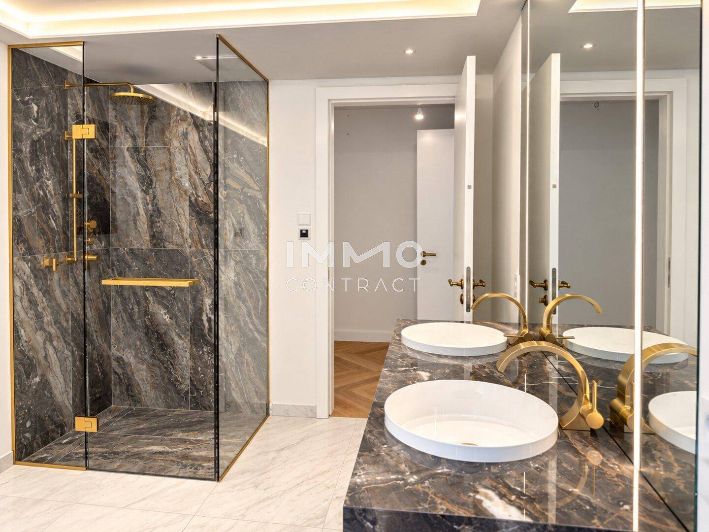 Modernes Badezimmer mit luxuriöser begehbarer Dusche, doppelten Waschbecken und dunklen Marmoroberflächen.