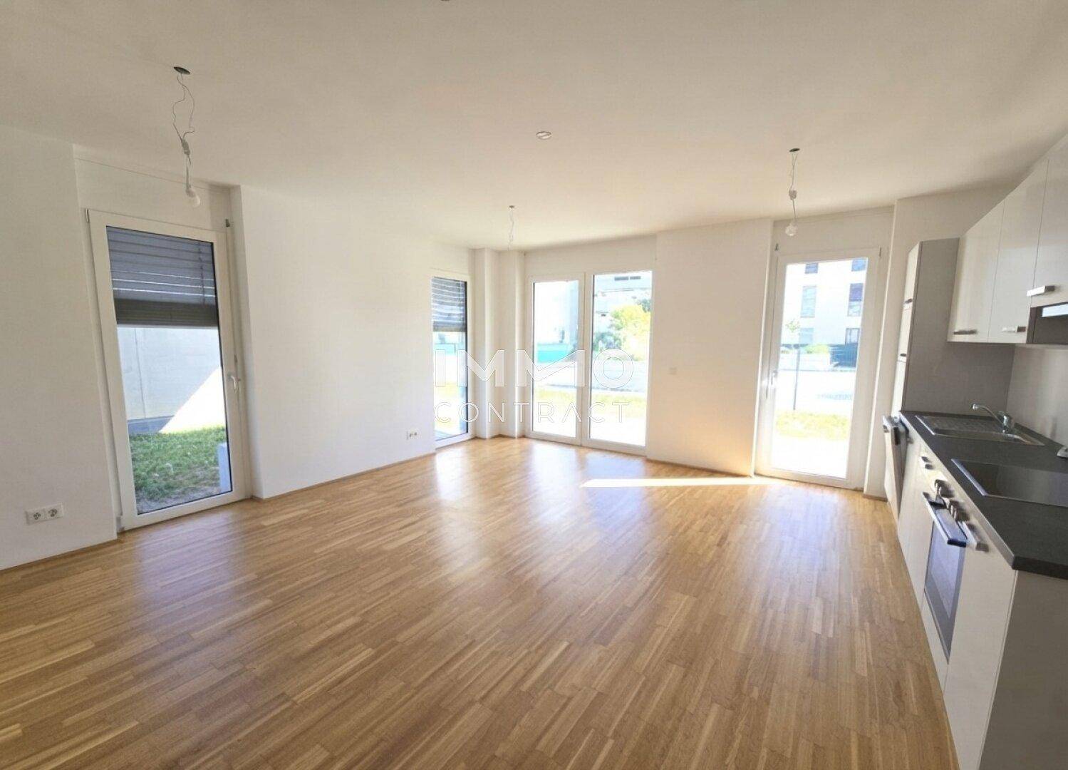Geräumiger Wohn- und Essbereich mit integrierter Küchenzeile und Zugang zum Garten.