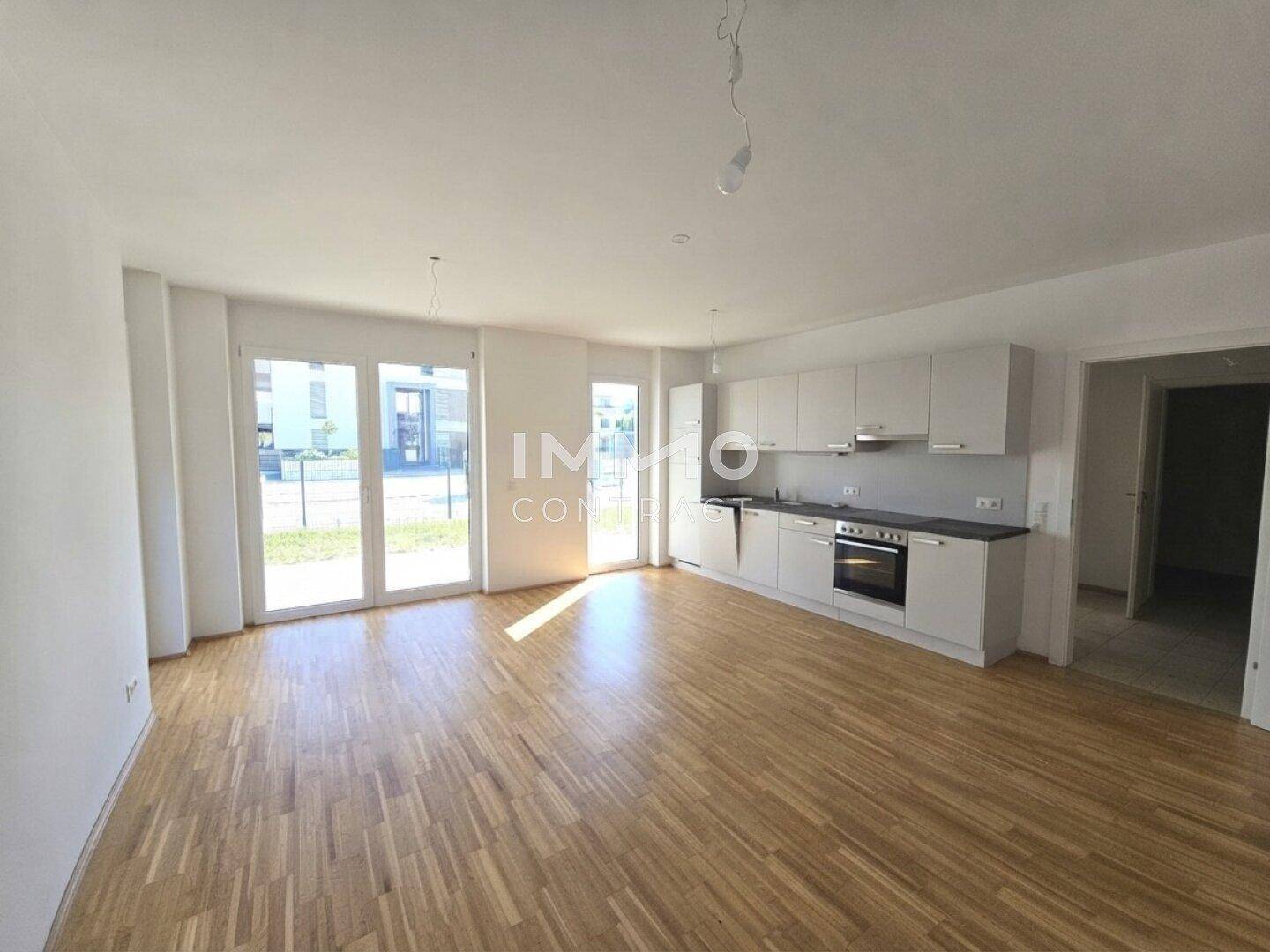 Lichtdurchfluteter Wohn-Essbereich mit integrierter Küche und direktem Zugang ins Freie.
