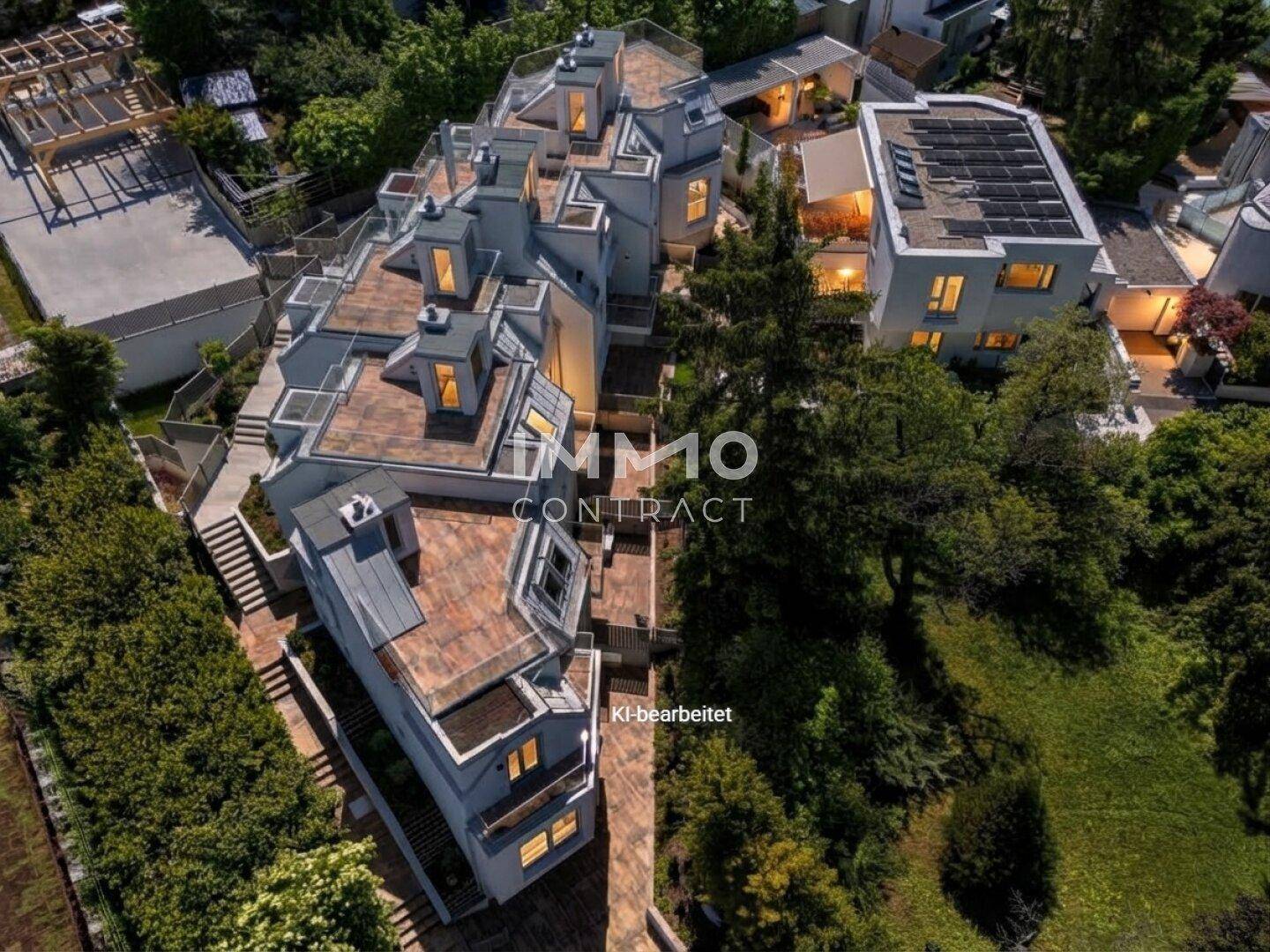 Luftaufnahme eines modernen Wohnkomplexes mit Flachdächern und umgebenden Bäumen.