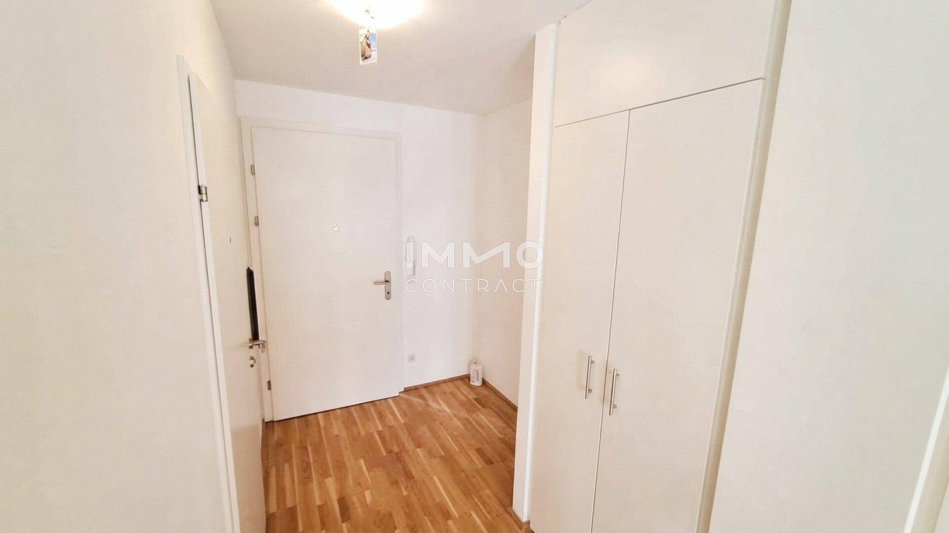 Heller Flur mit praktischem Einbauschrank und Holzboden, bietet Stauraum.