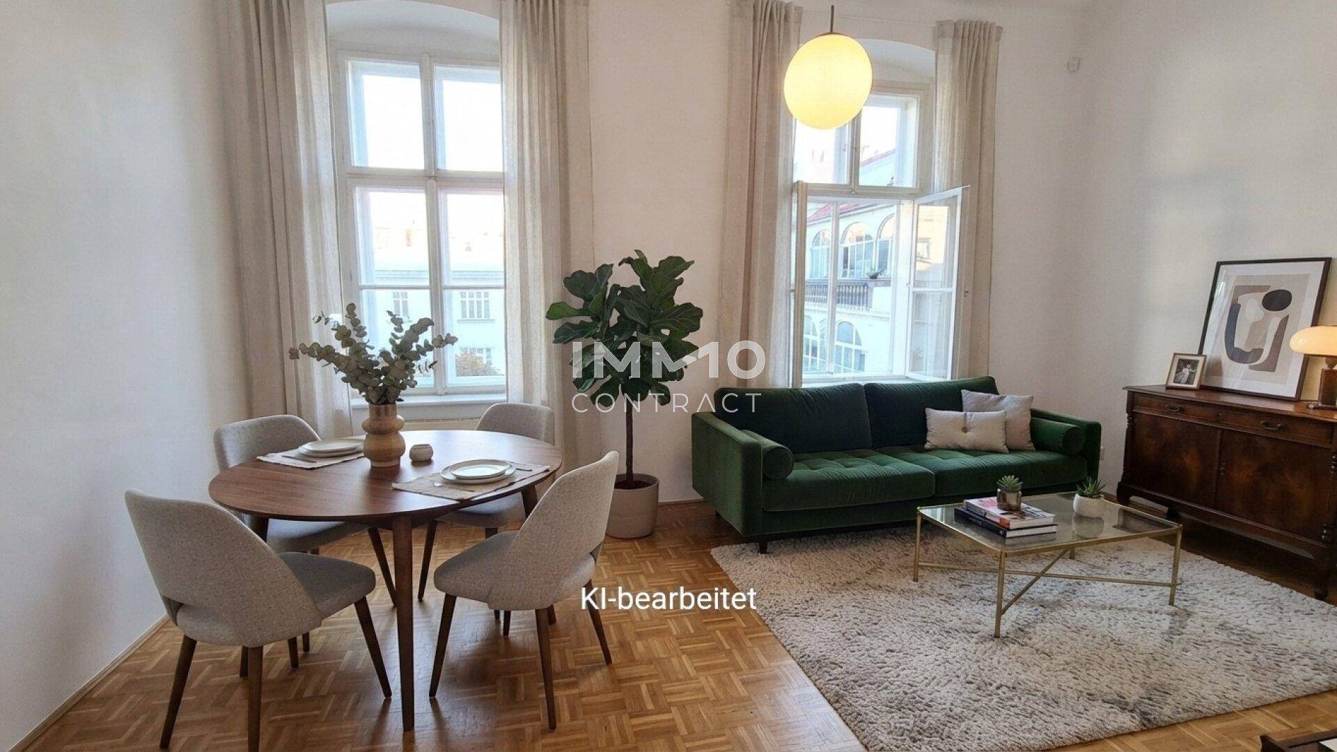 Gemütlicher Wohn-Essbereich mit Parkettboden, grüner Couch und modernem Esstisch.