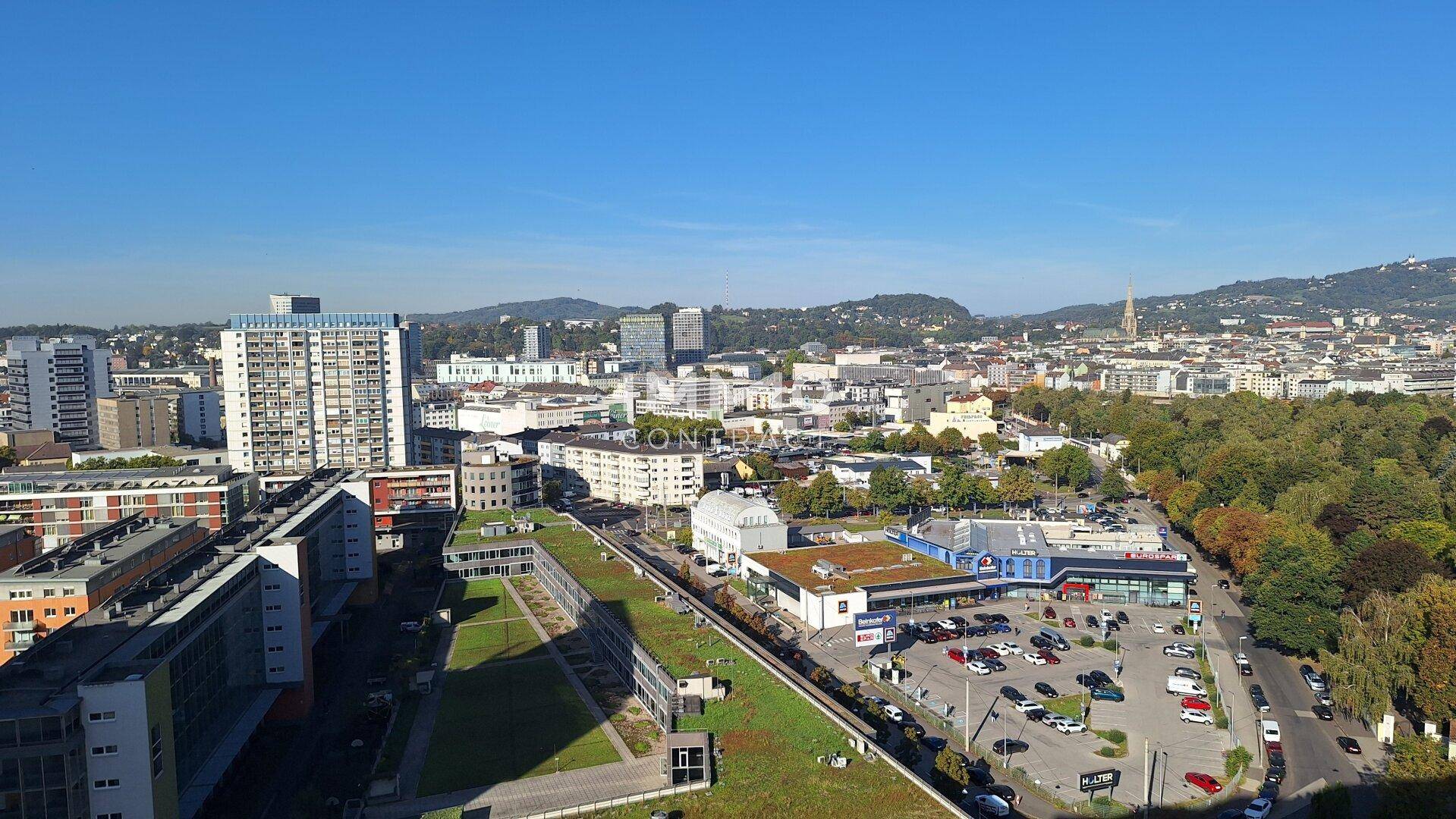Panoramablick über die Stadt mit Wohngebäuden, Grünflächen und Infrastruktur.