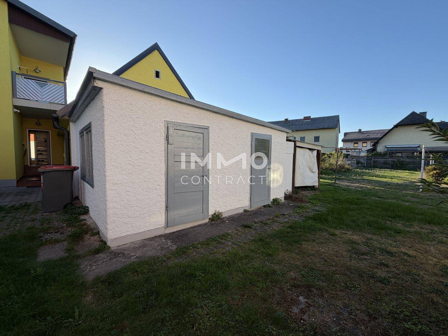 Kleines Nebengebäude oder Gartenhaus mit zwei Türen im hinteren Gartenbereich.