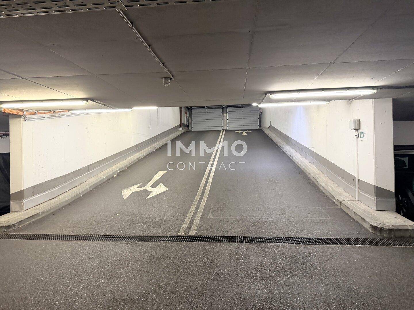 Zufahrtsrampe zu einer Tiefgarage, gut beleuchtet und mit klaren Markierungen.