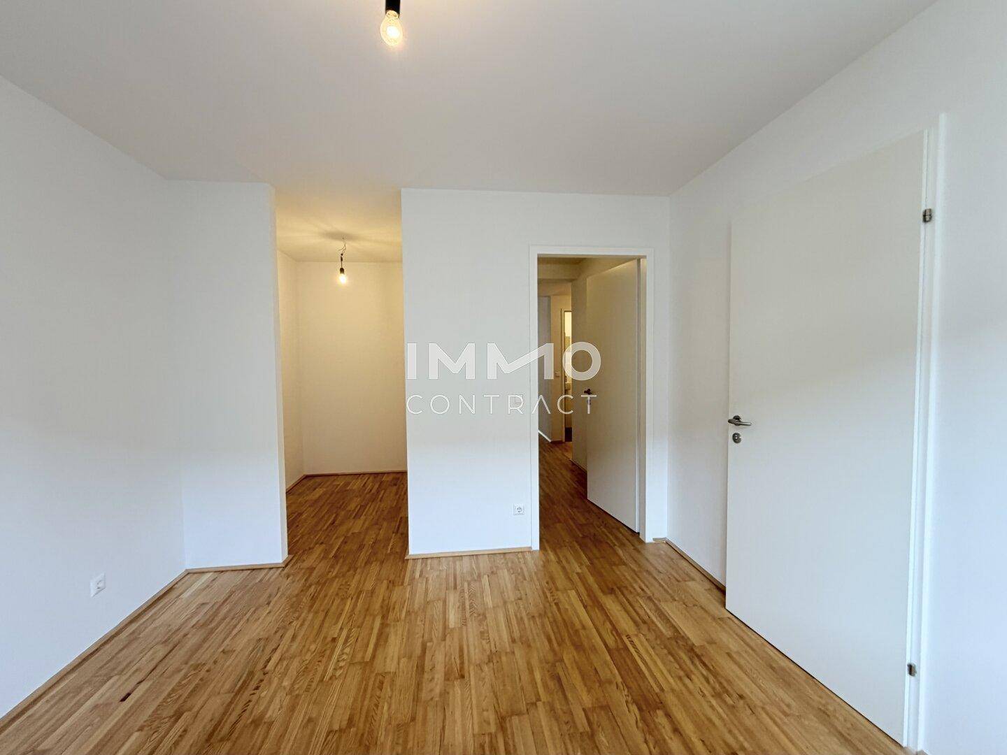 Heller Flur mit Parkettboden, der zu den verschiedenen Räumen der Wohnung führt.