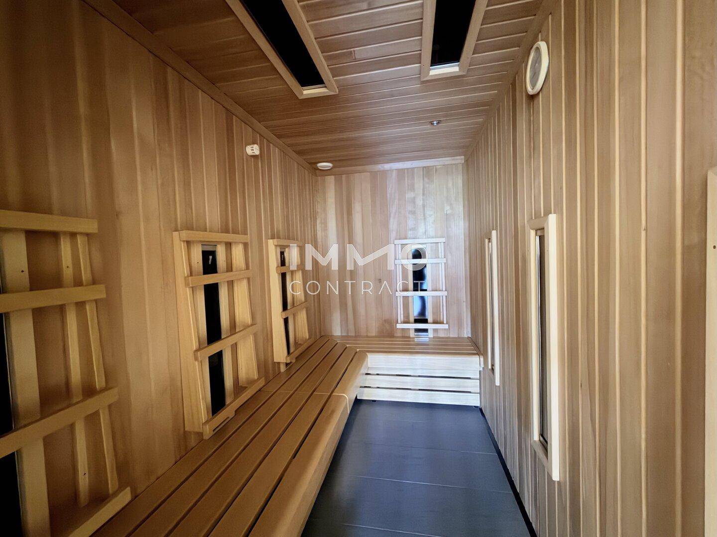 Helle Saunakabine aus Holz mit mehreren Sitzbänken für Entspannung und Wellness.