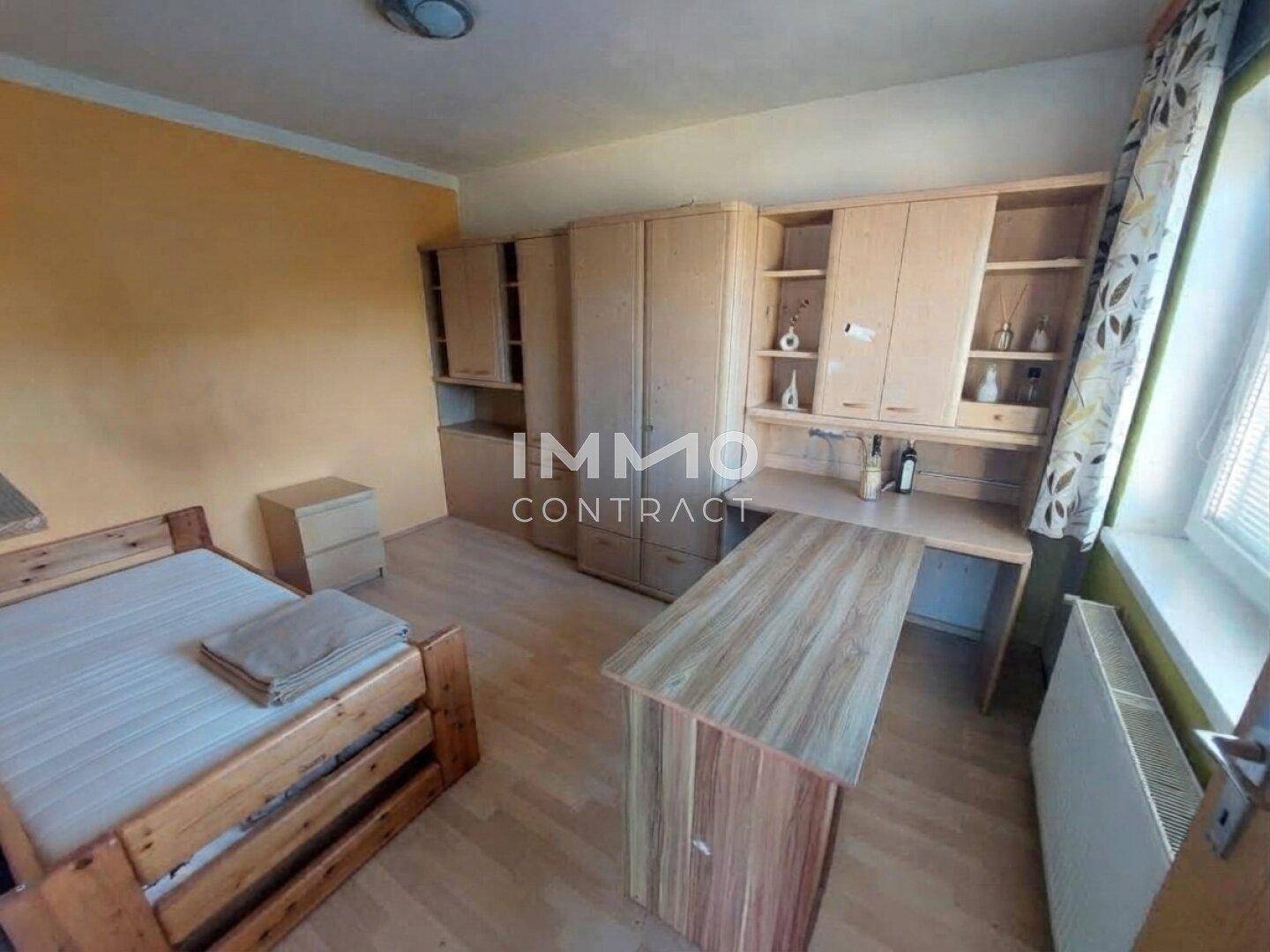 Helles Zimmer mit Bett, Schreibtisch und Einbauschränken, vielseitig nutzbar.