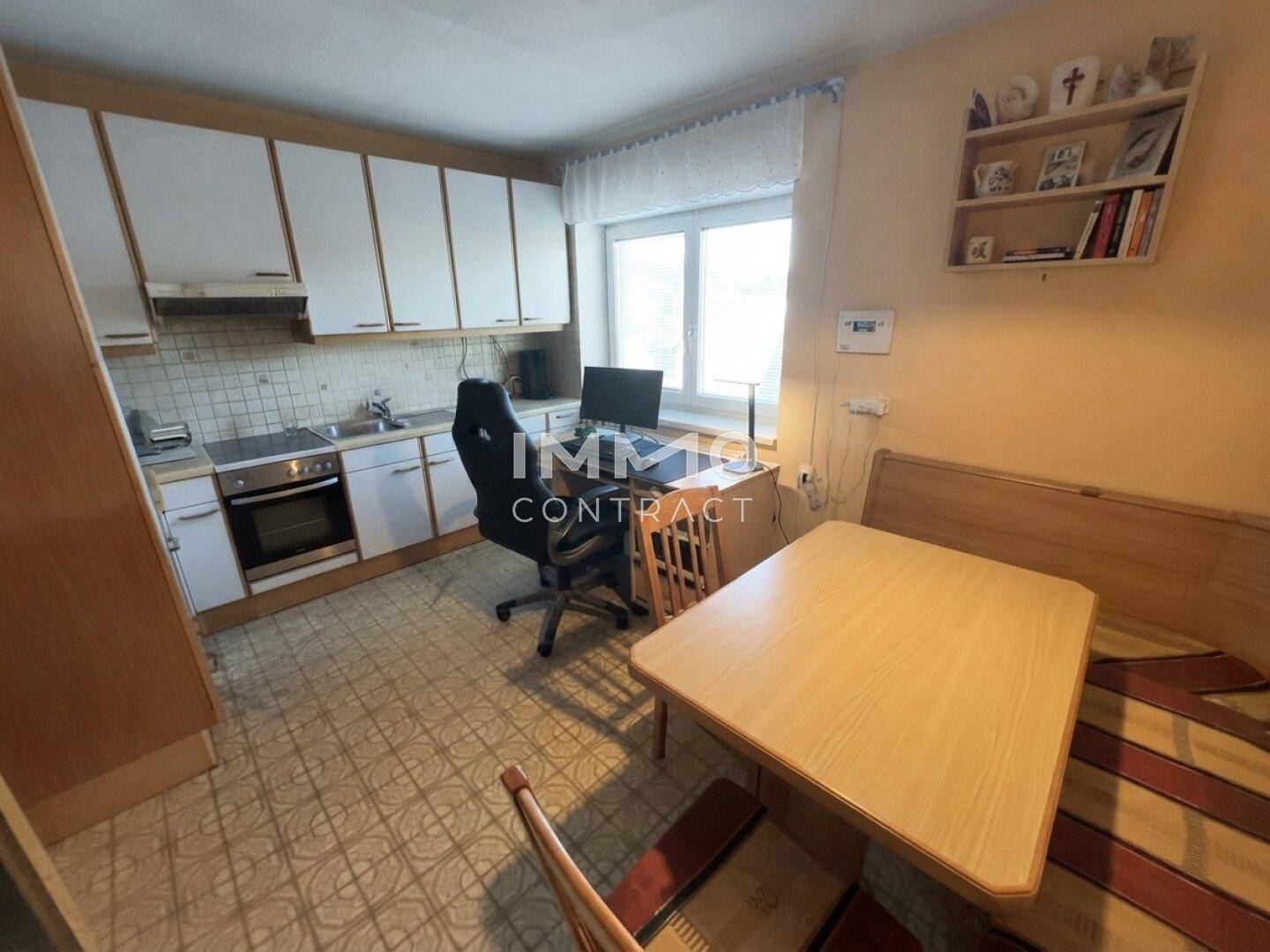 Funktionale Küche mit Essbereich, Einbaugeräten und Fenster für Helligkeit.