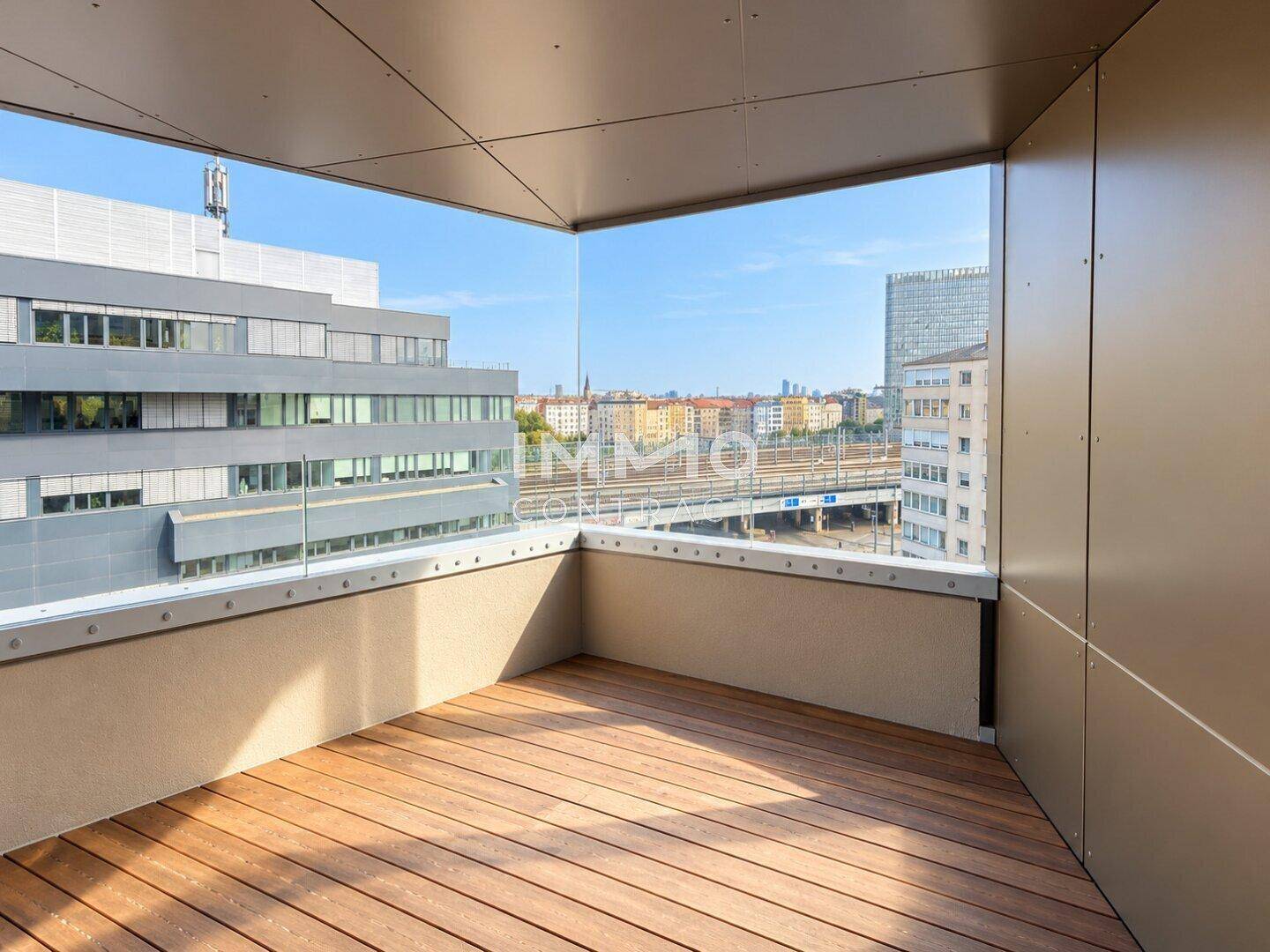 Moderner Balkon mit Holzboden und Glasgeländer bietet einen weiten Blick über die Stadt.