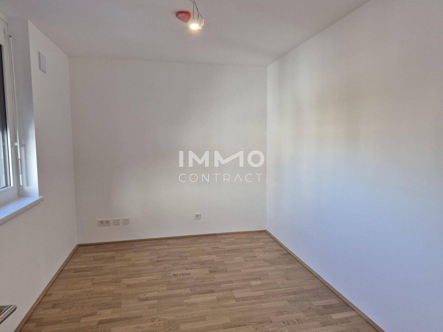 Kleiner, heller Raum mit Parkettboden und einem Fenster, ideal als Schlaf- oder Arbeitszimmer.