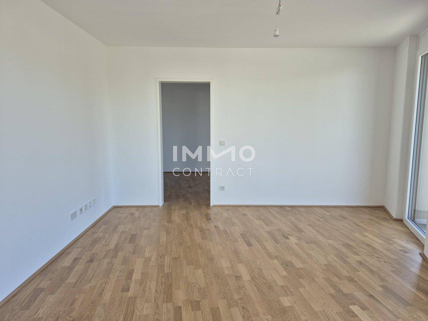 Leeres Zimmer mit hellem Holzboden und weiß gestrichenen Wänden, bereit zur individuellen Gestaltung.