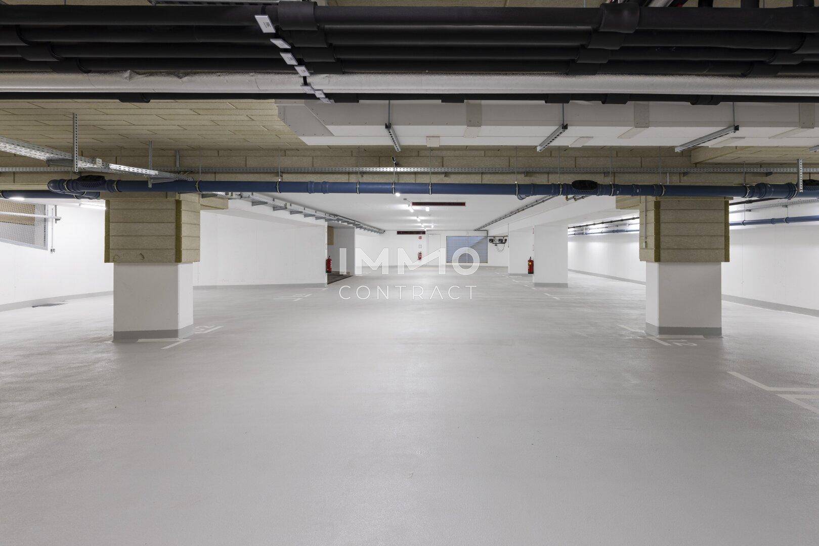 Weitläufige Tiefgarage mit vielen Stellplätzen und guter Beleuchtung.