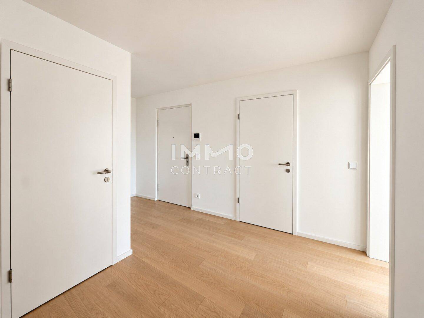 Heller Flur mit Holzboden und mehreren Türen, der verschiedene Räume der Wohnung verbindet.