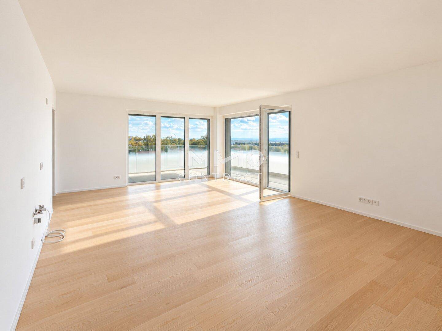 Helles, leeres Wohnzimmer mit großen Fenstern und Zugang zu einem Balkon, ideal für offenes Wohnen.