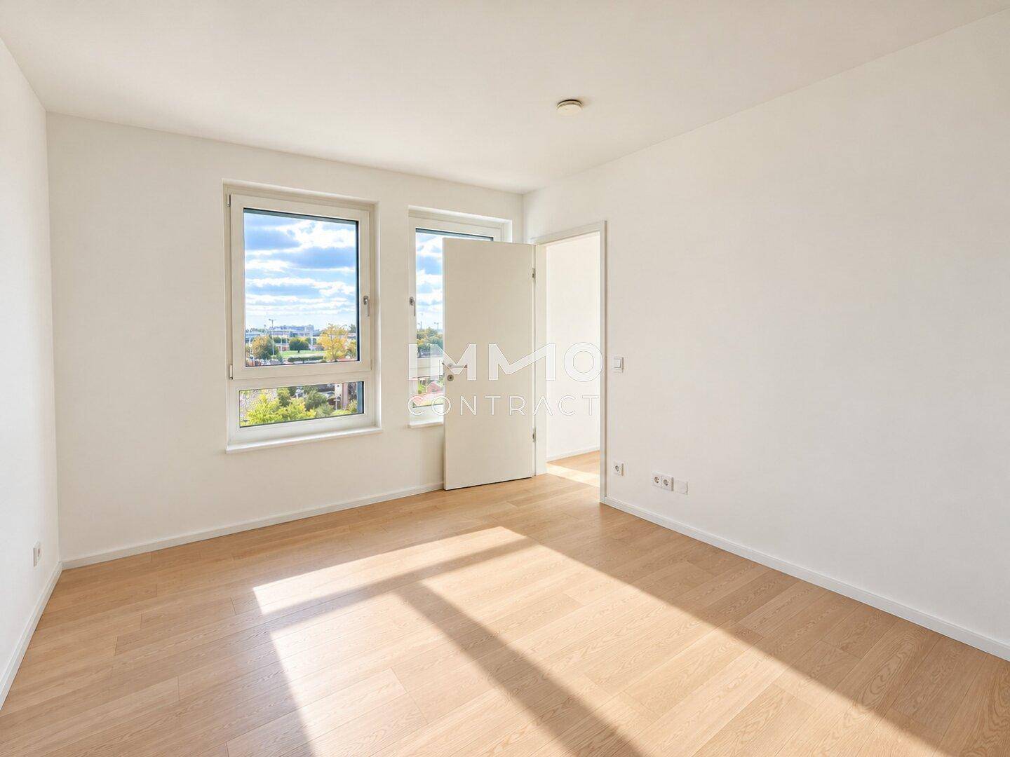 Helles Schlafzimmer mit zwei Fenstern, die viel Tageslicht und einen Blick ins Grüne bieten.
