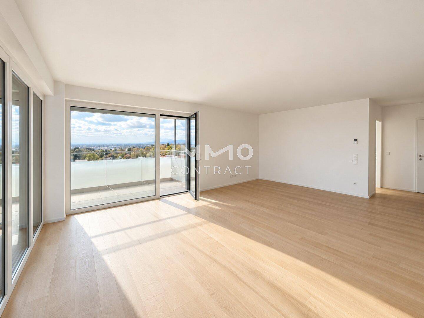 Großzügiger Wohnbereich mit hellem Parkettboden und raumhohen Fenstern zum Balkon.
