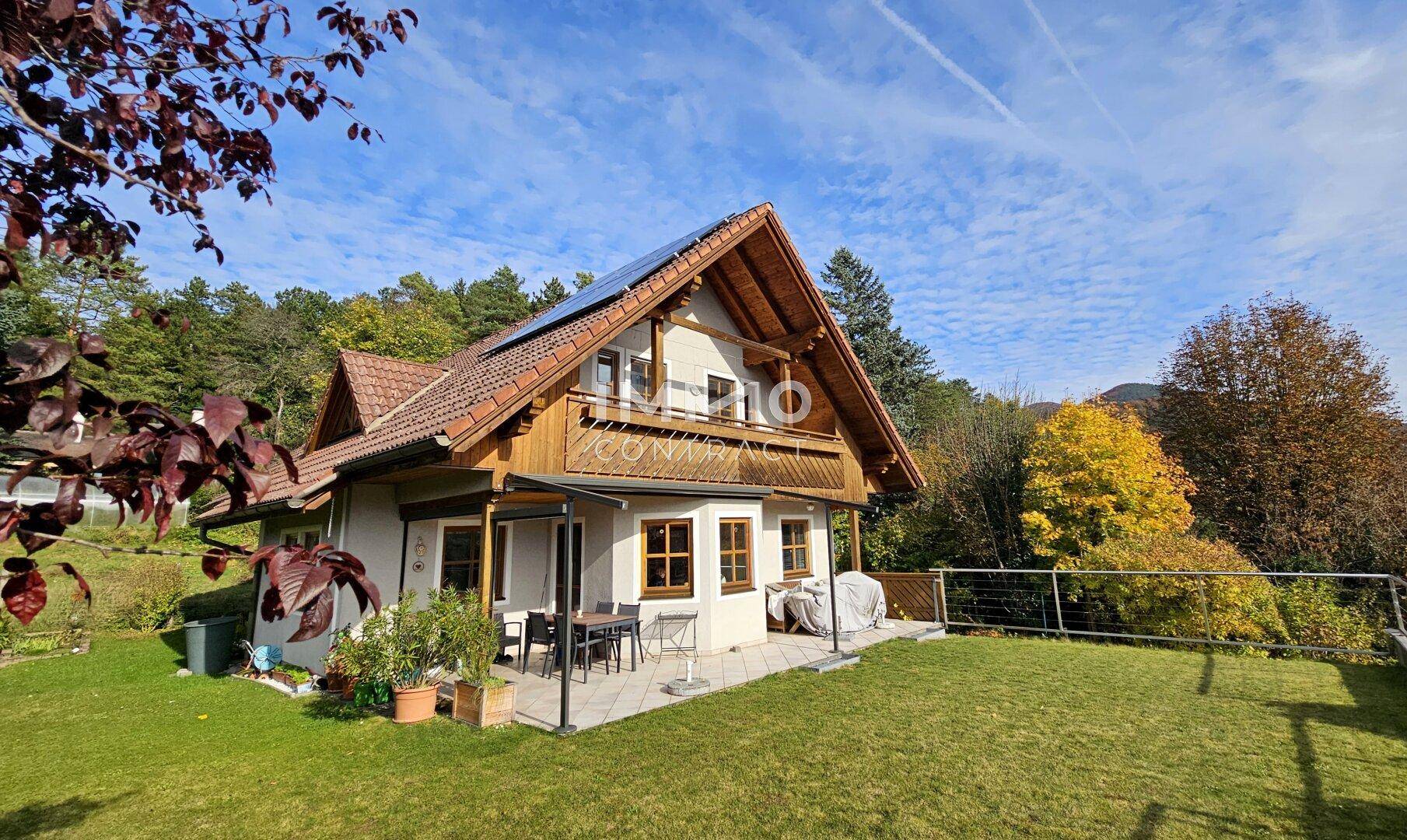 Charmantes Haus mit Garten, Terrasse und Solarpaneelen auf dem Dach.