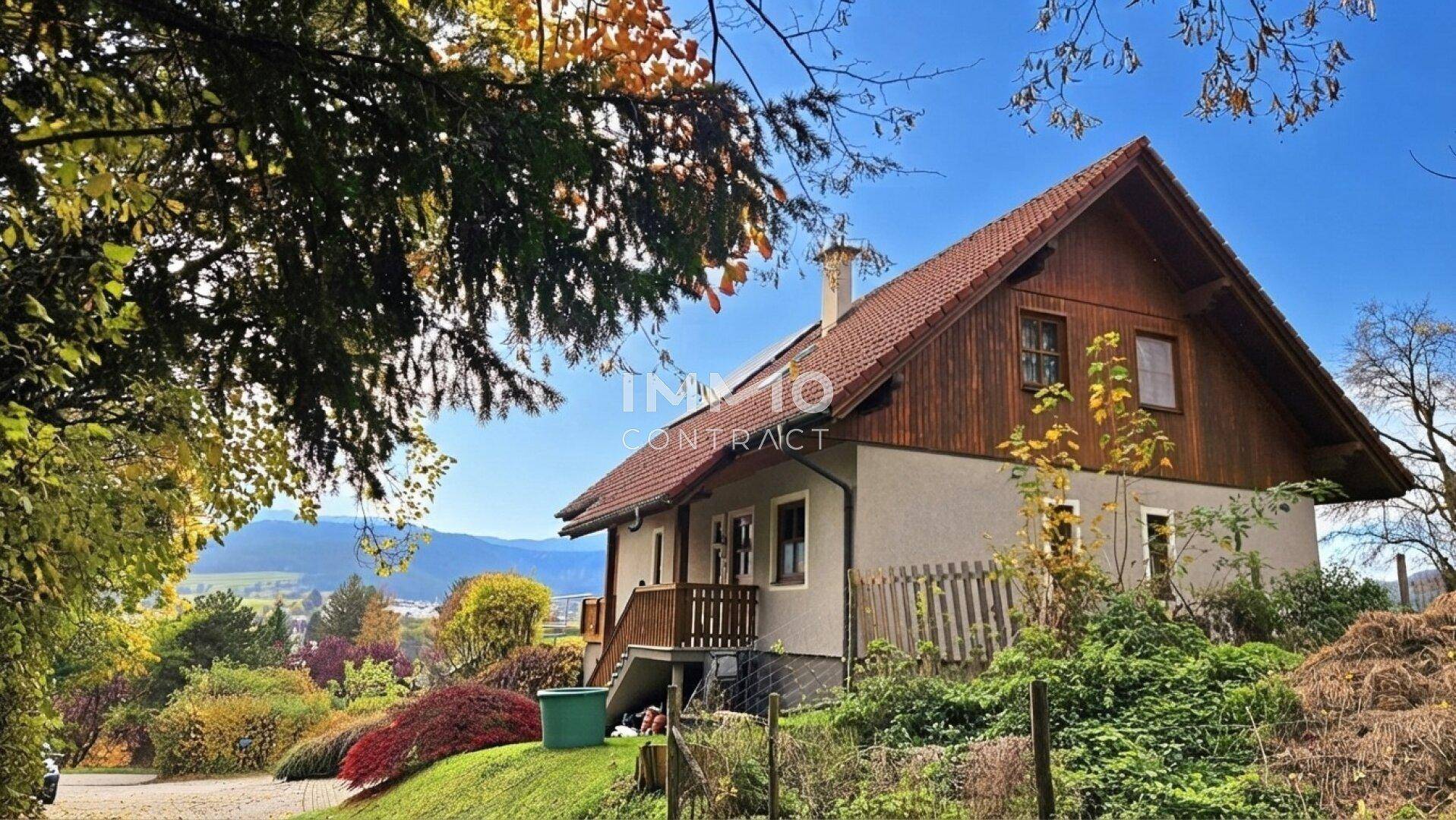 Charmantes Haus mit Holzelementen und Garten in ländlicher Umgebung.