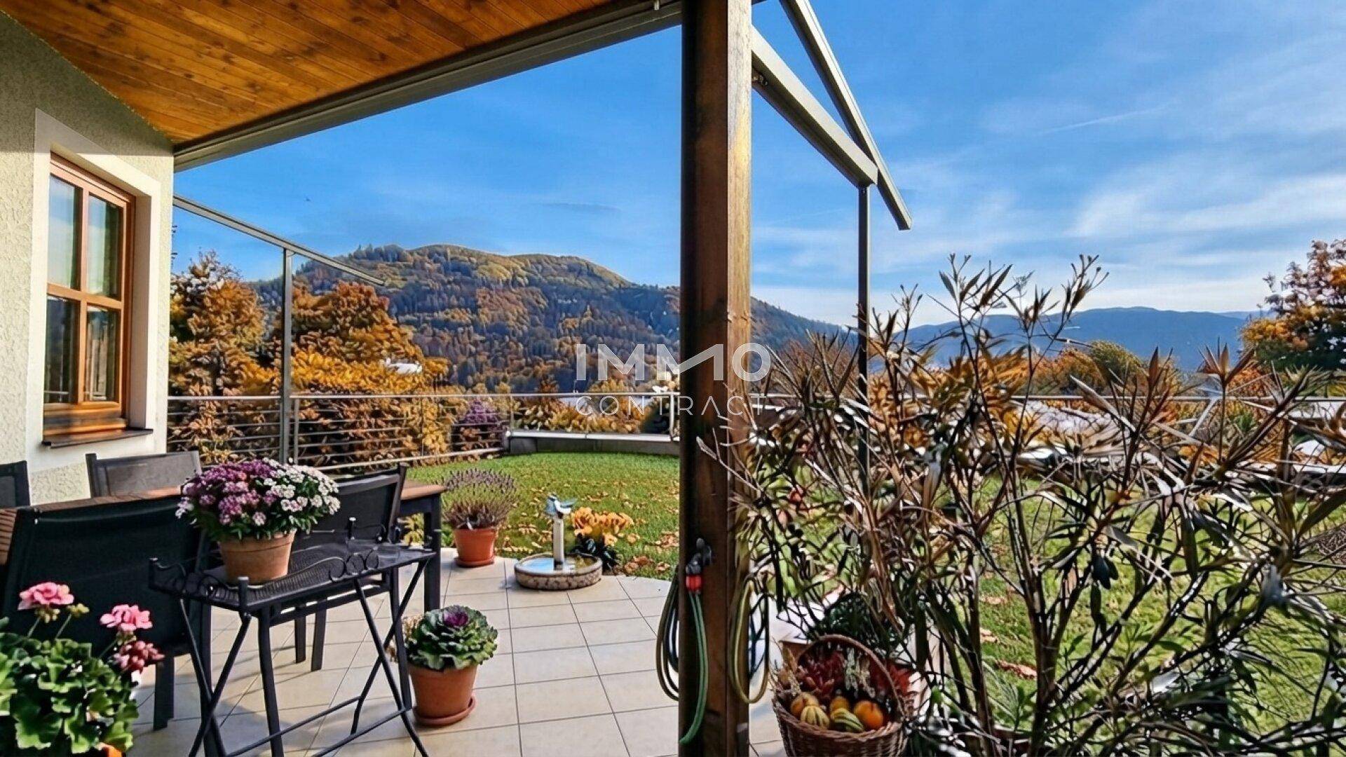 Überdachte Terrasse mit Bergblick und Gartenmöbeln, ideal zum Entspannen.