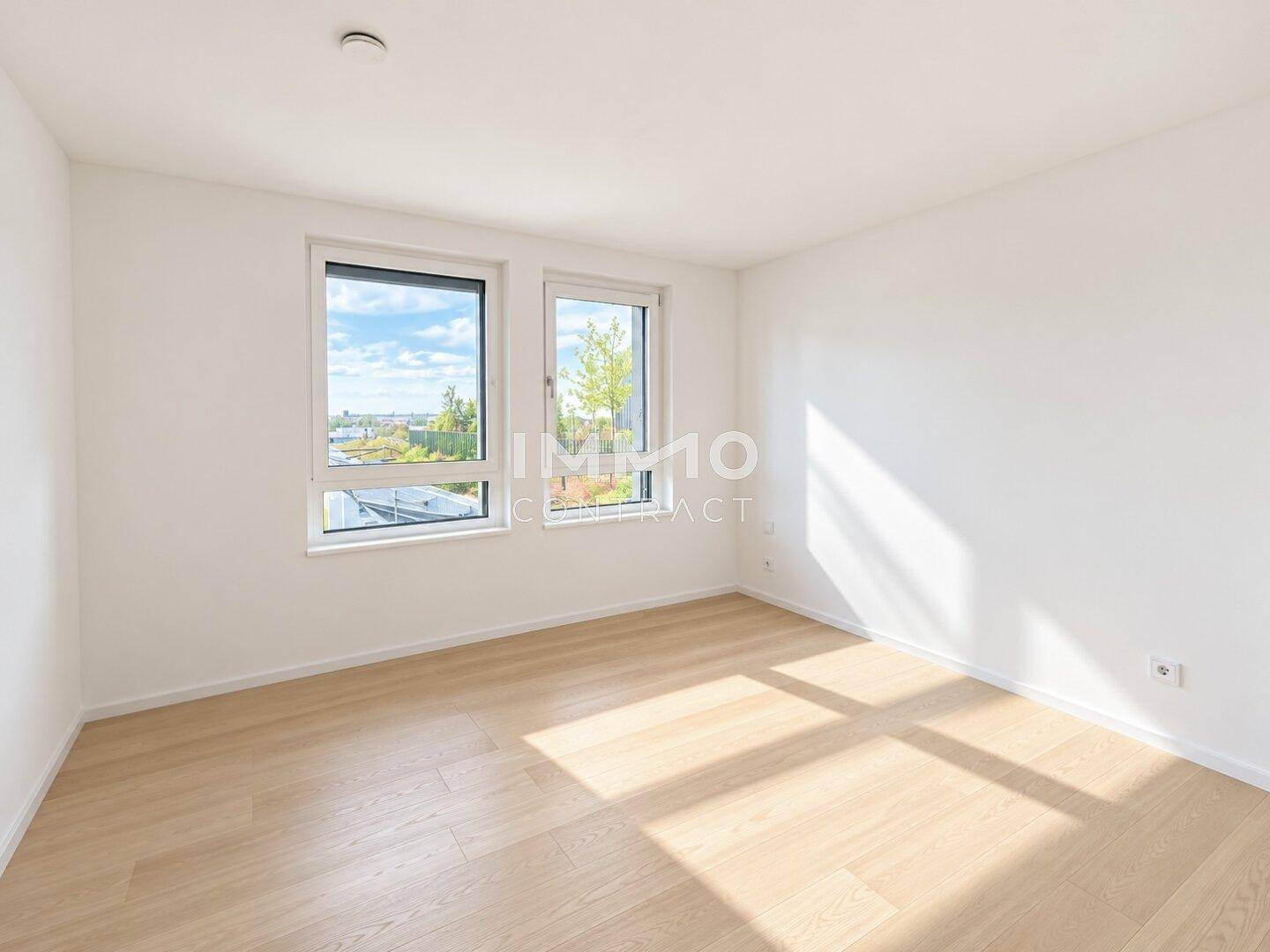Helles Schlafzimmer mit Holzboden und großen Fenstern, ideal für natürliche Belichtung.