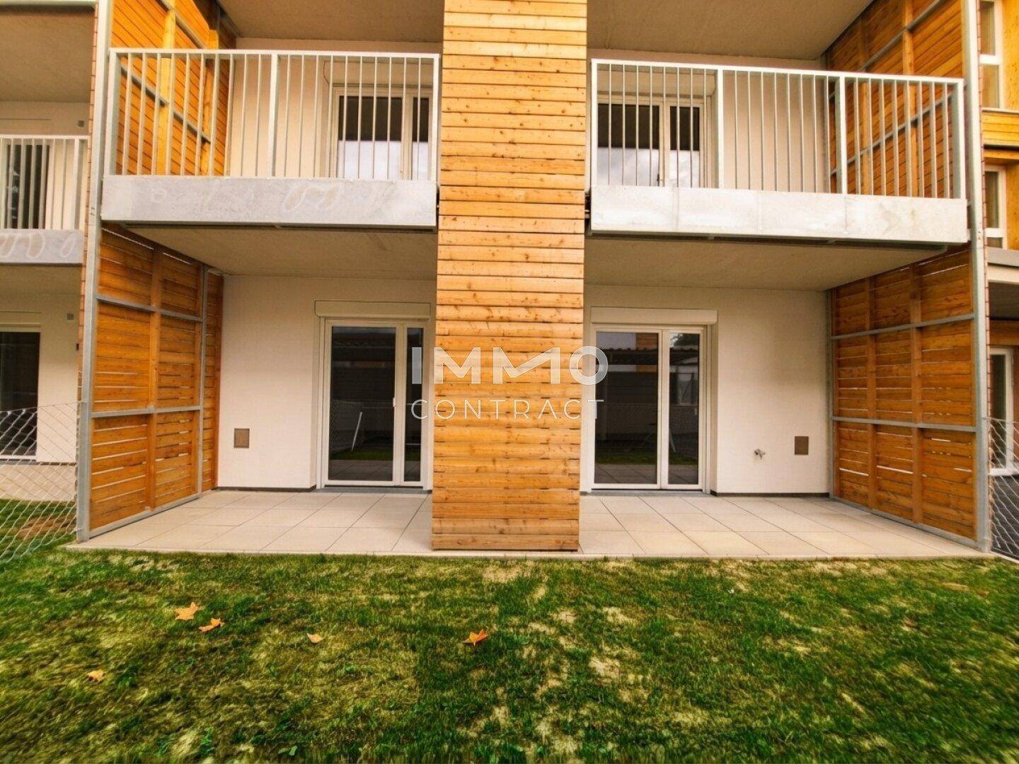 Erdgeschoss-Terrasse mit Holzelementen und Zugang zum Gartenbereich.