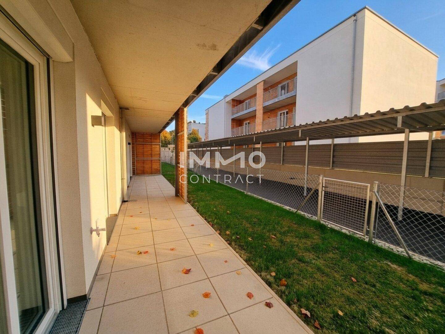 Überdachte Terrasse oder Loggia mit Fliesenboden und Blick ins Grüne.