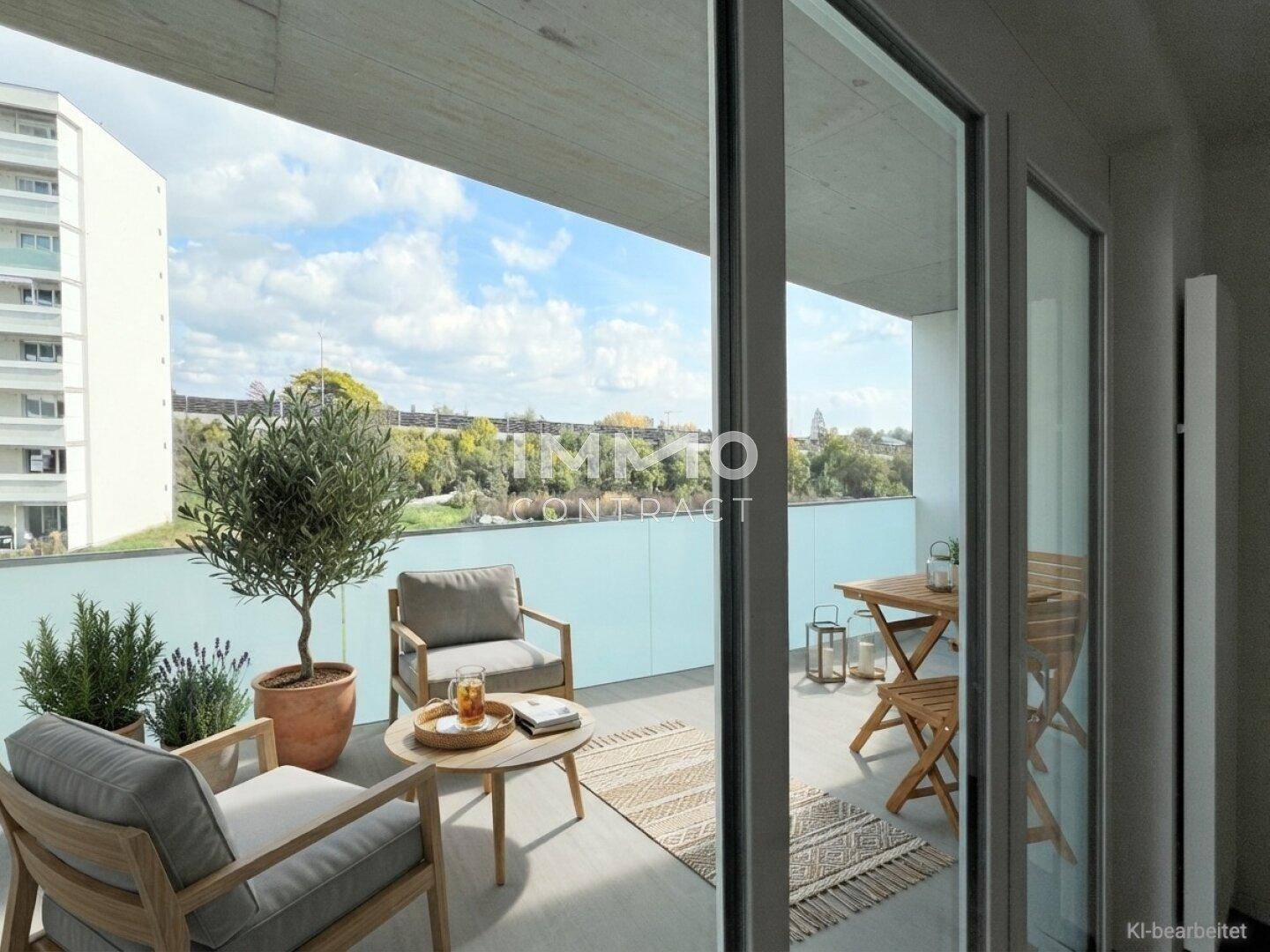 Möblierter Balkon mit bequemen Sitzgelegenheiten, Pflanzen und weitem Blick ins Grüne.