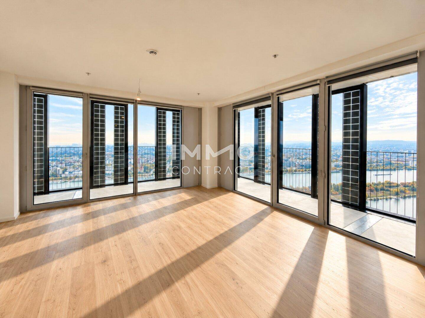 Helles Wohnzimmer mit Holzboden und großen Fenstern, die einen weiten Stadtblick bieten.